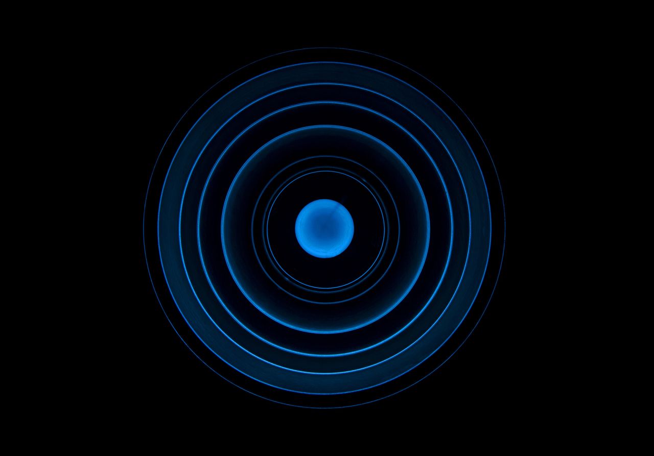 Abstract blue concentric circle pattern on a black background, ideal for futuristic designs.